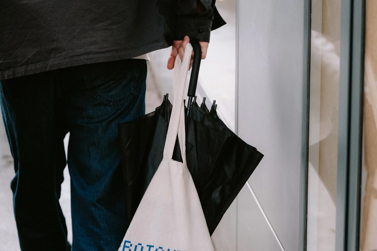 A person carrying a plain canvas tote bag