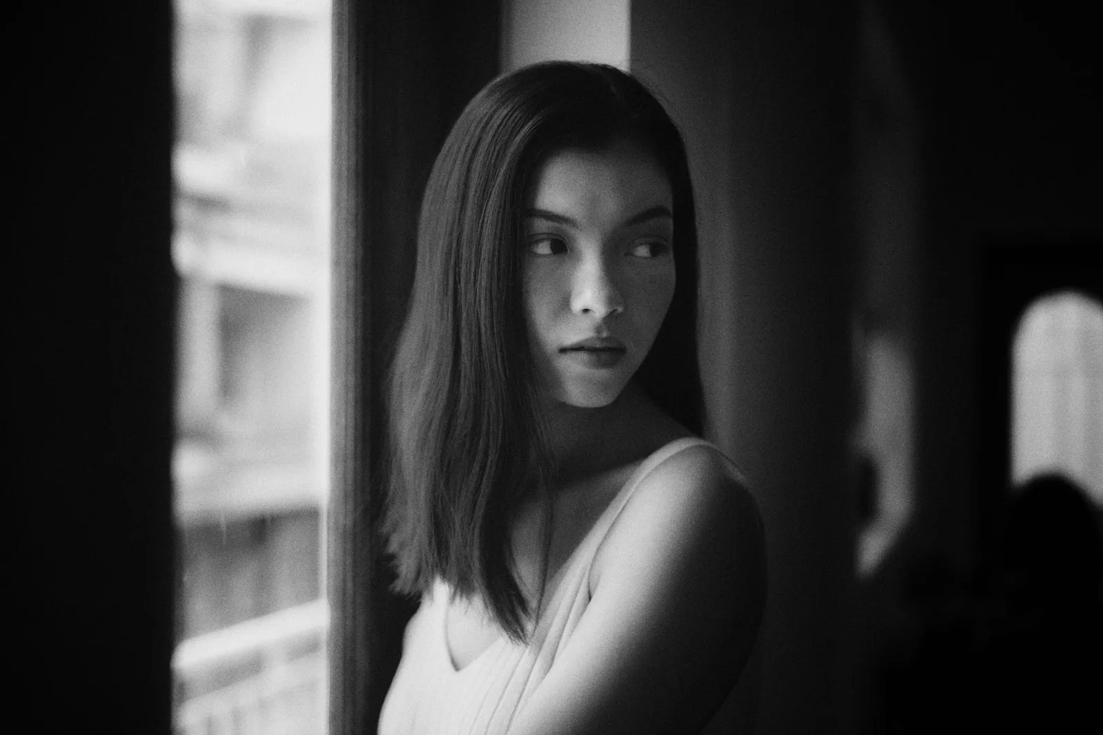 A person standing in soft light from a large window