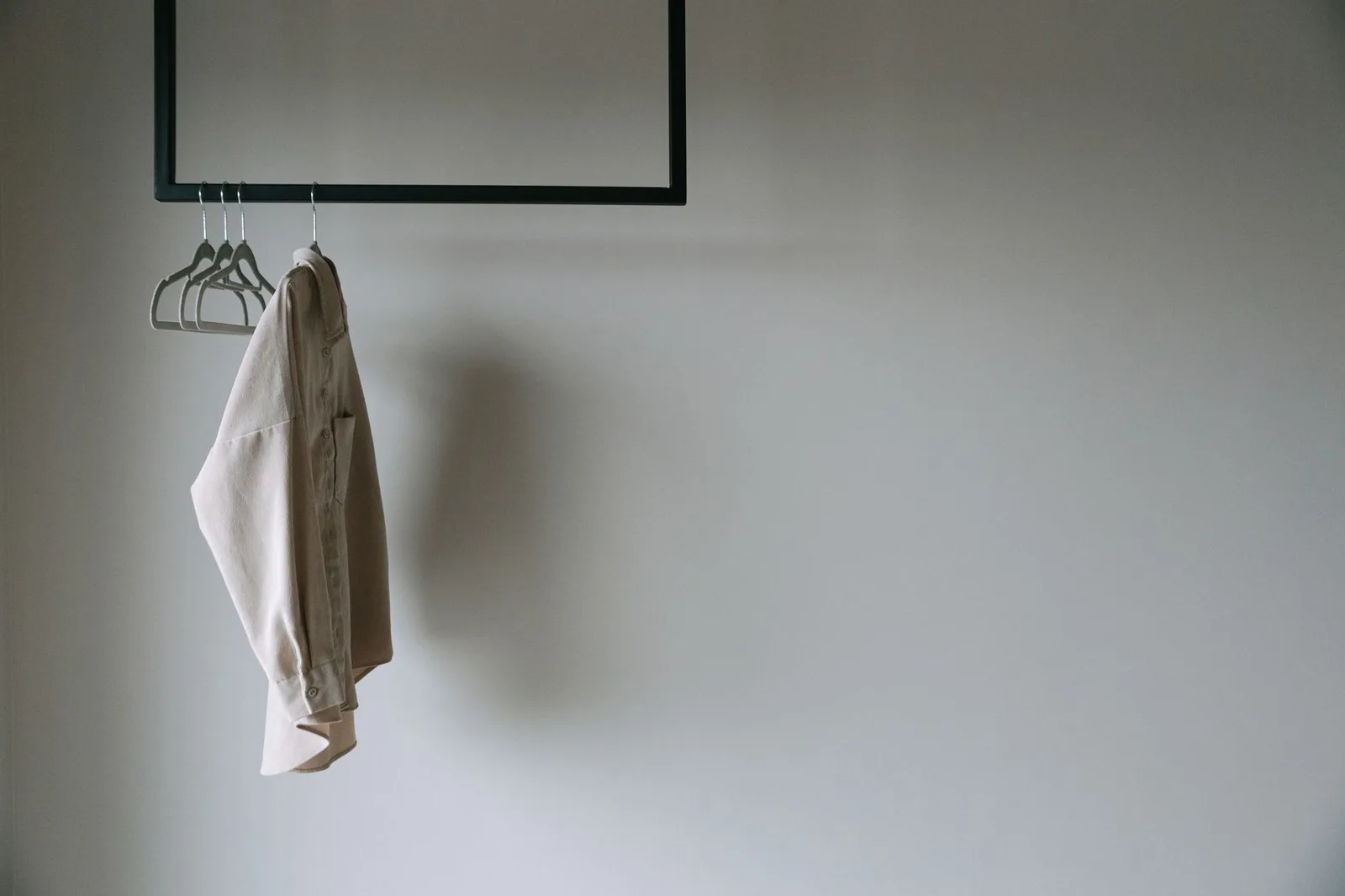 A canvas chore coat hanging against a plain wall