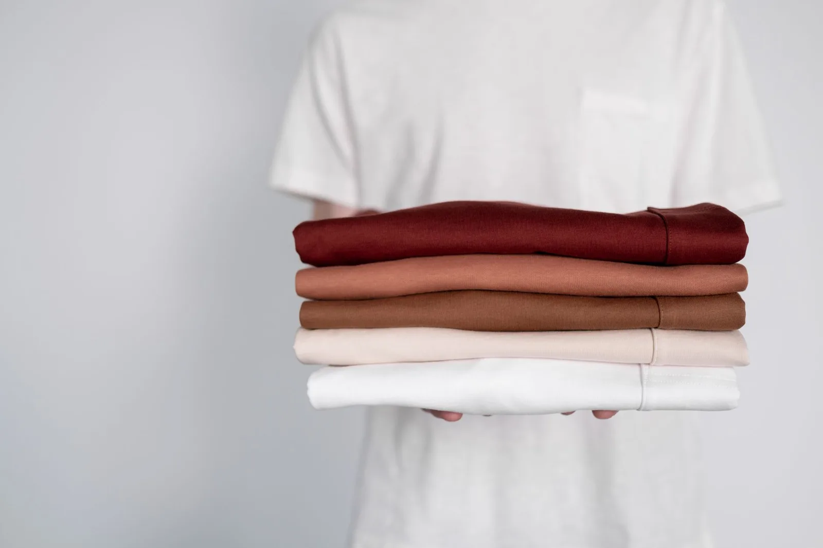 Neatly folded garments arranged on a wooden shelf