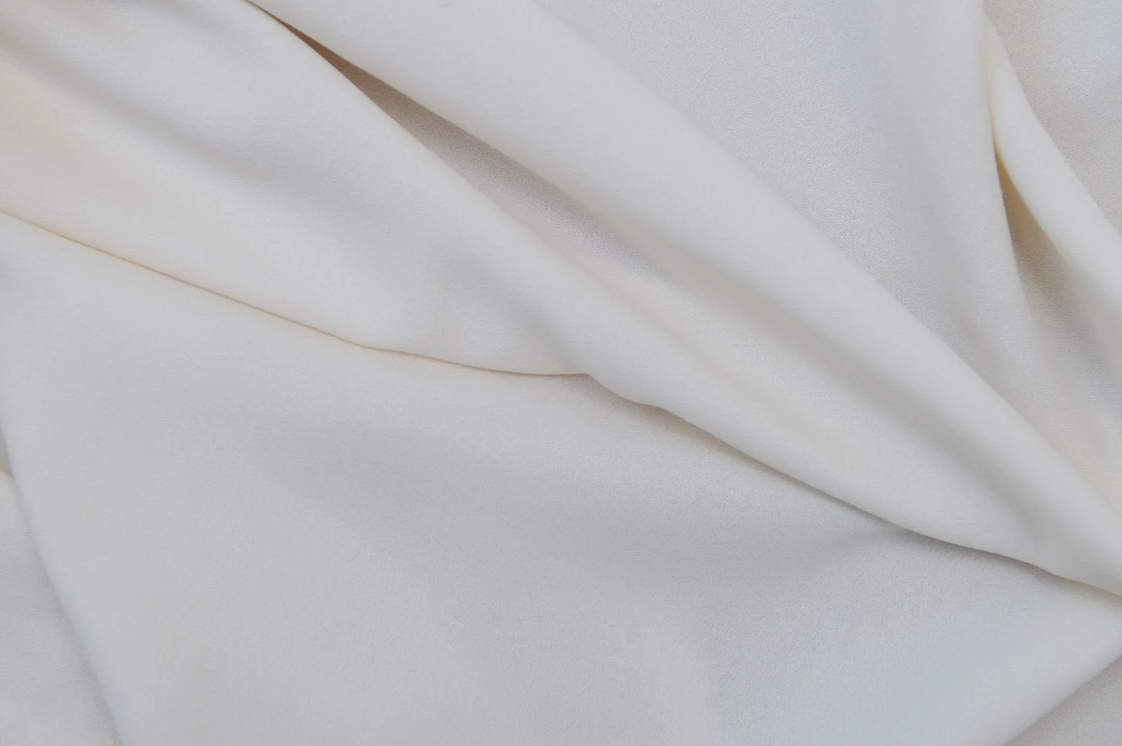 Fabric falling in soft folds against a plain background