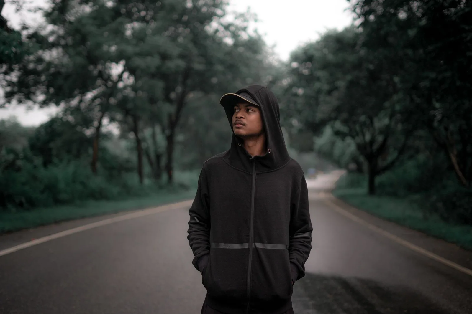 A person wearing a zip-up hooded sweatshirt outdoors