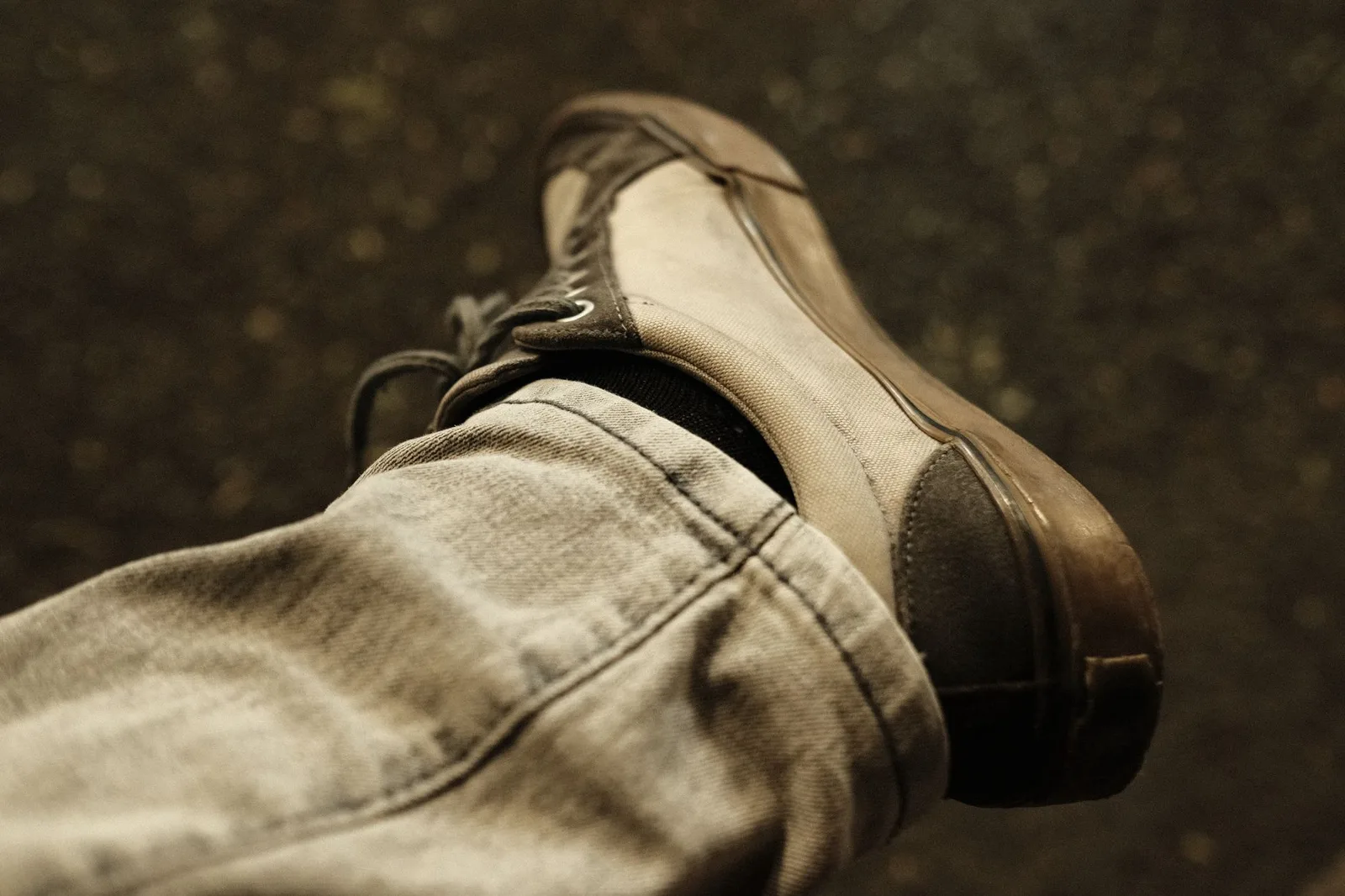 A pair of low-profile white leather sneakers photographed from the side