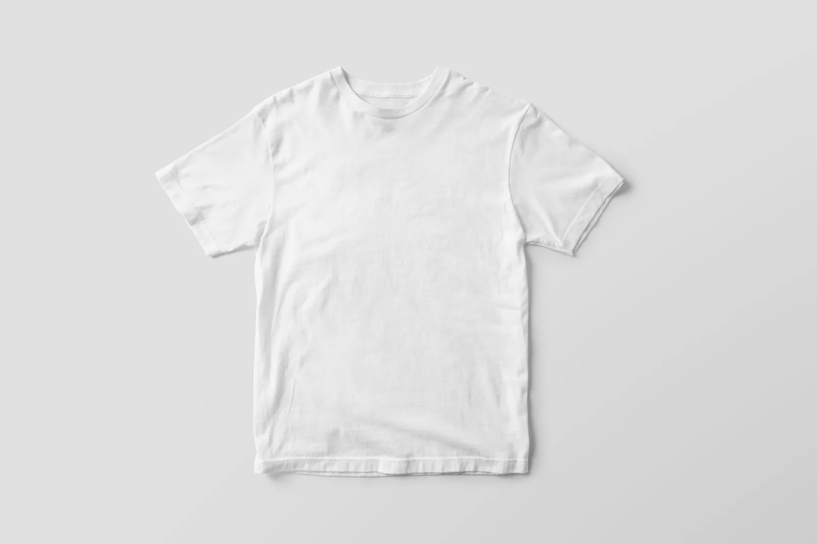 A plain white T-shirt hanging against a neutral background